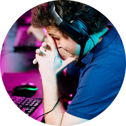 Giocatore di eSport in preda allo stress, con indosso delle cuffie da gioco durante un'intensa partita competitiva, concentrato su un PC da gioco ad alte prestazioni in un moderno centro di gaming.